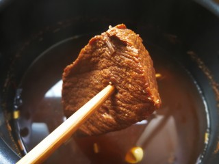 6、麻辣卤汤牛肉面,煮到能用筷子插进去为宜，不要太烂，否则切块的时候容易散而不成形。将牛肉浸泡到汤里自然放凉，凉后用漏网过滤掉锅里的卤药渣，牛肉入碗里盖上保鲜膜放冰箱冷藏，剩下来的汤汁用来做面条的汤水。