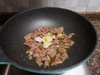 10、莴笋炒牛肉,放入生姜和大蒜片翻炒均匀。