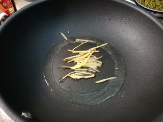 8、腌酸豆角懒人法,锅里油加热,放入生姜煸香。