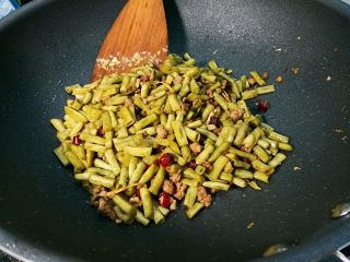 11、腌酸豆角懒人法,放入酸豆角翻炒,加入盐(看个人腌的豆角的咸度,看需不需要再放盐),鸡精,白糖,少许生抽,炒匀。