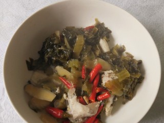 12、酸菜鱼,汤熬好后，用漏勺把酸菜等捞起，放在大汤碗里面，锅内只剩下鱼汤