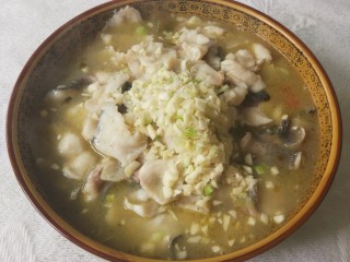 14、酸菜鱼,转中火，汤烧开后，煮一两分钟即可，加味精，连鱼带汤倒入刚才捞起的酸菜碗中，大蒜剁碎，洒在碗中