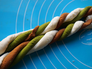 6、雨花石汤圆,将三条面团像搓麻花绳一样搓在一起使其颜色均匀