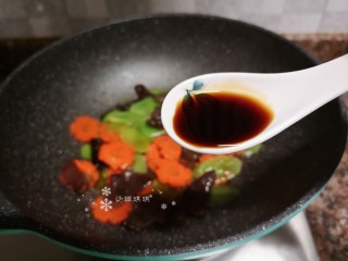 9、莴笋炒木耳,倒入适量生抽翻炒均匀。