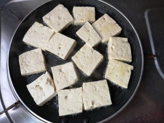 9、十味 八珍豆腐,平底不粘锅烧热，多下点油，把豆腐摆入，中小火慢煎。