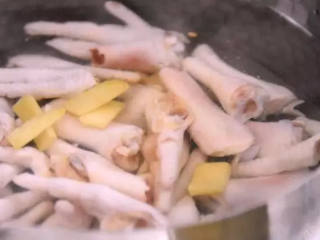 2、超级好吃的世界杯下酒零食——酸辣凤爪,冷水下锅，放入姜片、料酒，煮沸 