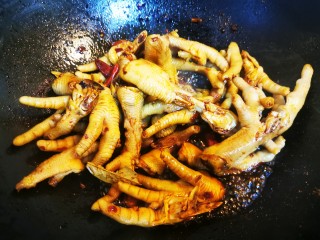 10、香辣卤鸡爪,将鸡爪倒入锅中和配料一起翻炒一会儿