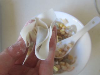 9、玉米虾仁馄饨,再将折叠按压紧即可;