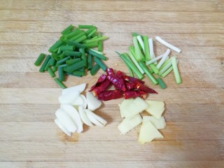 3、红烧土豆,小葱洗干净，葱叶和葱白分开切成段，大蒜和生姜分别洗干净切成片，干红辣椒掰成两半。 