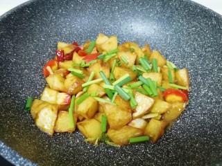 10、红烧土豆,放鸡精翻炒均匀，撒上葱叶关火出锅。 