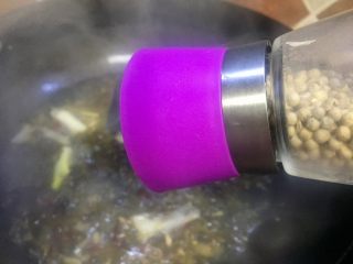 14、#年味#水煮酸菜滑肉片,加入现磨白胡椒粉，加盖熬制酸菜汤汁