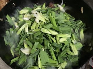 24、辣炒腊肉,加入蒜叶。