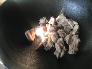 2、红烧土豆羊排,热锅倒入羊排爆炒,炒干水分。