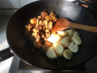 9、红烧土豆羊排,倒入土豆翻炒均匀。