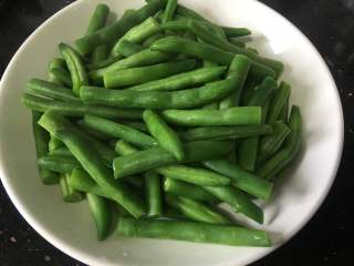 4、干煸芸豆,然后切两段沥干备用