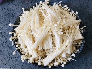 4、金针菇这样做，比肉还好吃，零失败的蒜蓉金针菇,捞出来控干水份，摆在盘子里，盘子要深盘，金针菇蒸好会蒸出很多汤汁。