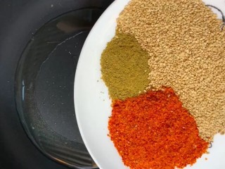 6、麻辣里脊条,锅留底油放入熟芝麻，孜然粉，辣椒粉