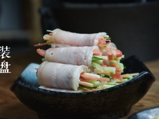 6、蒜泥白肉卷,五花肉平铺于菜墩上，黄瓜丝、胡萝卜丝依次放入肉片上，卷成卷，装盘。