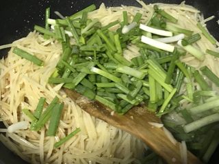 12、家常小炒—酸辣土豆丝,倒入葱段。再次翻炒均匀，马上过来起锅。