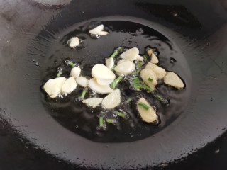 8、平菇炒鸡蛋,利用锅里的底油，放入蒜片葱花炒香。