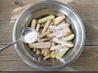 7、避风塘茄子,此时茄子条表面会有一些水份析出，加入适量的裹炸粉，颠匀，使茄子条表面薄薄覆盖一层裹炸粉即可。