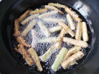 8、避风塘茄子,锅中宽油烧至5-6成热，将茄子条挨个下锅，翻动一下使切条均匀炸透。