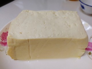 1、家常烧豆腐,一块豆腐，清水冲一下。