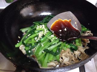 9、舞茸蚝油菜心,倒入菜心、剩下的一半蒜碎、蚝油翻炒均匀