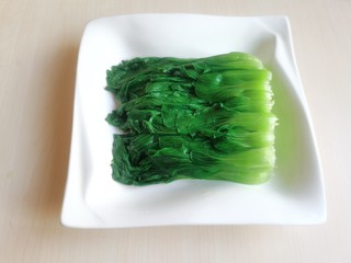 8、蒜蓉小油菜,将焯水后的小油菜均匀的码在金针菇的上面。