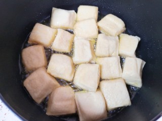 4、油菜豆腐,炸锅里倒多一点食用油烧热，放入小豆腐。