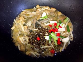 9、酸辣汤羊肉卷,接着放入蒜,葱,小红尖椒和花椒炒香。