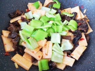12、素炒千叶豆腐,下入青椒翻炒至断生。