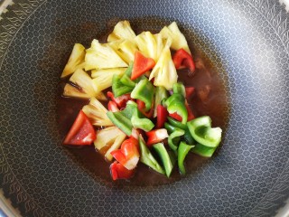 10、香菠咕咾腐竹,一边用铲子滑动,一边煮开。然后下入彩椒和菠萝块。