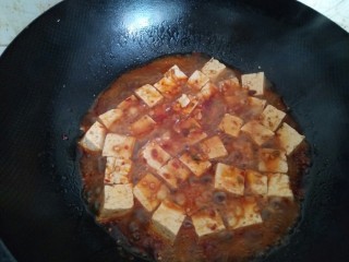 6、麻辣豆腐,加水，放入豆腐，盐、一品鲜酱油和糖少许，小火收汁。