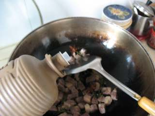 6、川味红烧牛肉面,加入适量料酒，继续翻炒至七八分熟。