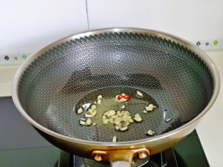 5、卷心菜炒粉丝,起油锅，加入蒜和辣椒炒香。