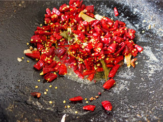 8、冷吃兔,改小火将干红辣椒与花椒、三萘煸香。