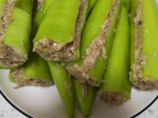 11、青椒酿肉,肉馅塞进青椒里面，塞好肉馅把青椒一合，刮掉多余的肉馅，只要青椒里面塞的够贴合，不用太满