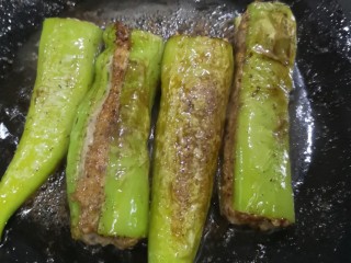 12、青椒酿肉,锅里倒进适量油，放进塞好肉馅的青椒小火煎，一点要小火耐心煎，这样青椒的辣味会慢慢渗入肉馅里，也能把肉馅煎大半熟了