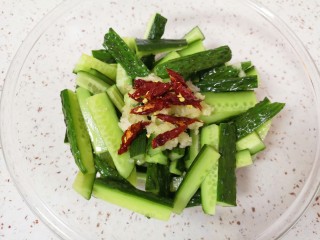 5、酸辣黄瓜条,黄瓜条倒掉腌制出来的水分，放上蒜泥和辣椒丝。