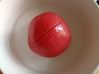 5、番茄土豆片,番茄顶部切花刀，在开水滚几圈。
