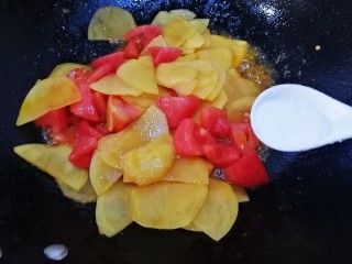 14、番茄土豆片,文火翻炒均匀，把番茄炒出红汁，放入一小勺盐炒匀。