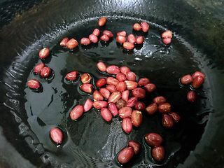 7、私房酸辣粉,锅中少放点油,小火,放入生花生米,慢慢炒熟,有噼里啪啦的声音出现,花生米外壳裂开后就可以出锅了。