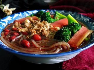 11、私房酸辣粉,煮好的粉条、西兰花、胡萝卜捞入汤碗中,放入花生米,肉末,撒上葱花和香菜,解馋又美味的酸辣粉就好了。