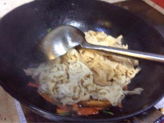 7、#年夜饭#炒豆皮,把泡好处理过的豆皮入锅。进行翻炒。