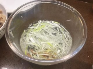 3、川版家常酱肉丝,和姜片一起加少许温水，水不要多，泡成葱姜水待用，等一会葱丝就会变成好看的弯弯