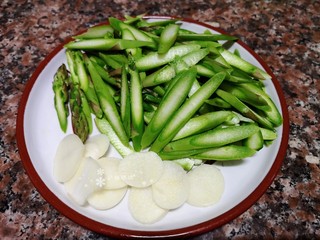 2、芦笋炒肉片,将芦笋、大蒜切成片。