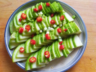 4、蒜蓉西葫芦,西葫芦摆盘，撒上葱花和红米椒段