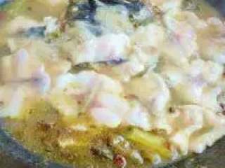 8、江湖酸菜鱼,调成微火后将鱼片一片片下入锅中，开中火再次沸腾、见鱼片变白即可倒入盆中，表面撒上香葱段和小香葱段