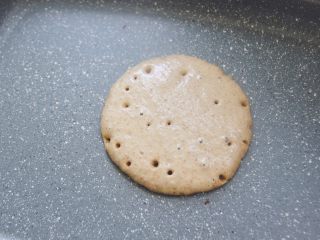 9、【燕麦香蕉Pancake】(素食低脂版),小火慢慢加热，待面糊表面有很多小气孔形成，不均匀分布整个面饼，就可以用铲子翻面了